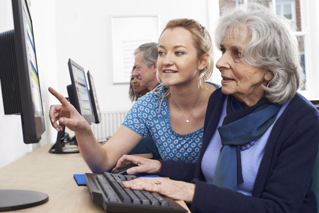 two women use a computer together