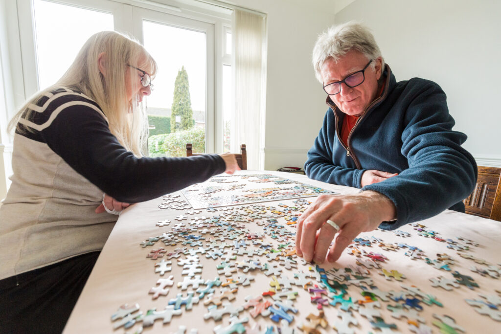 man and woman doing a puzzle together