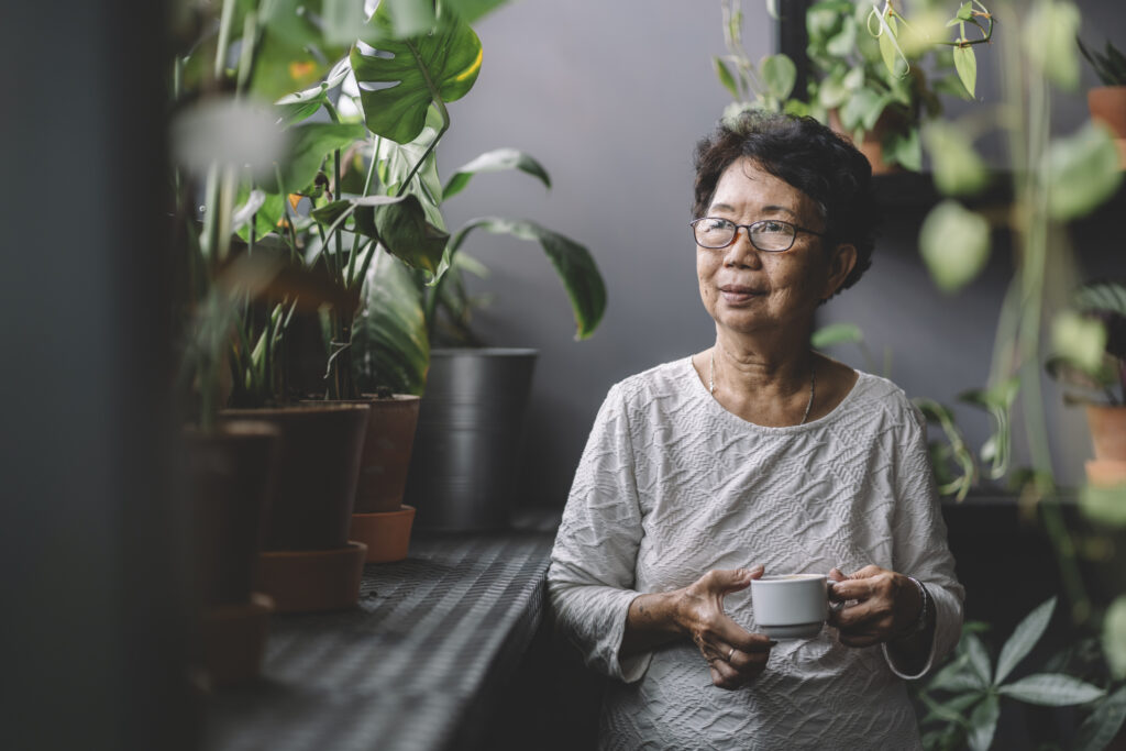 woman drinking coffee next to a window