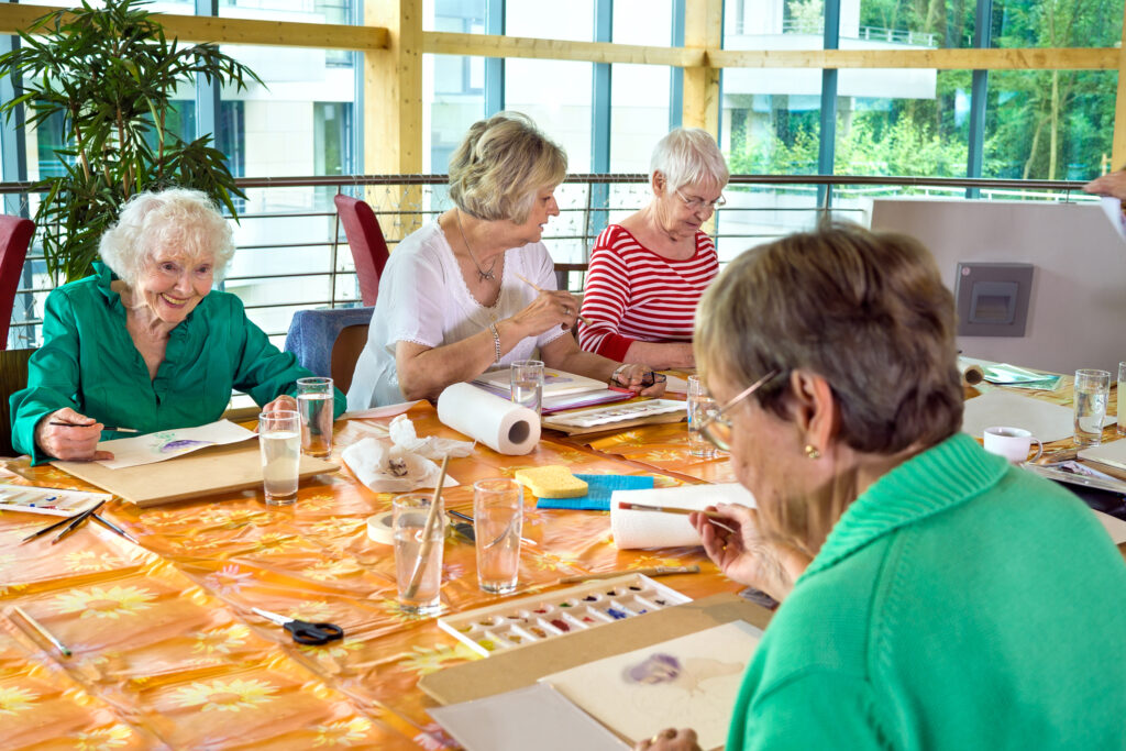 group of four older adults painting together