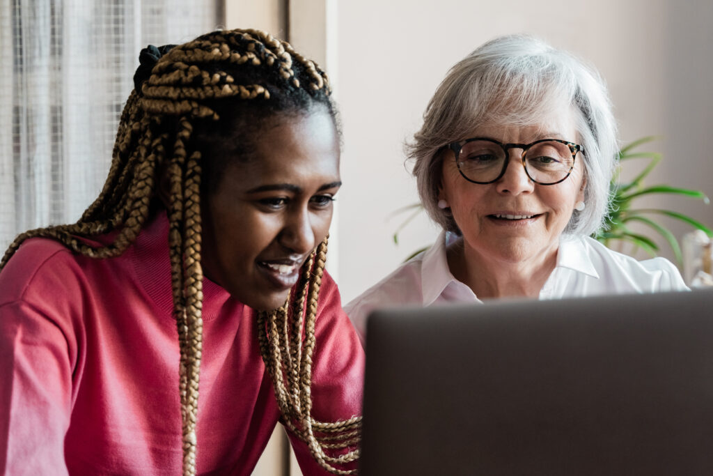 An older woman and a younger woman looking at a computer