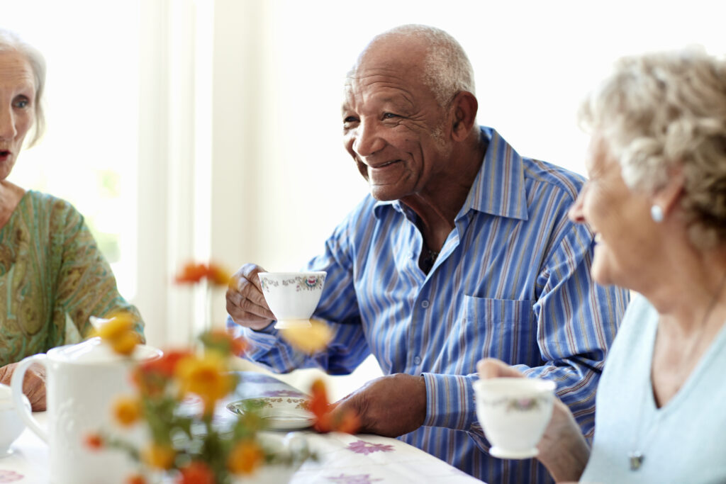 Smiling senior man having coffee with friends