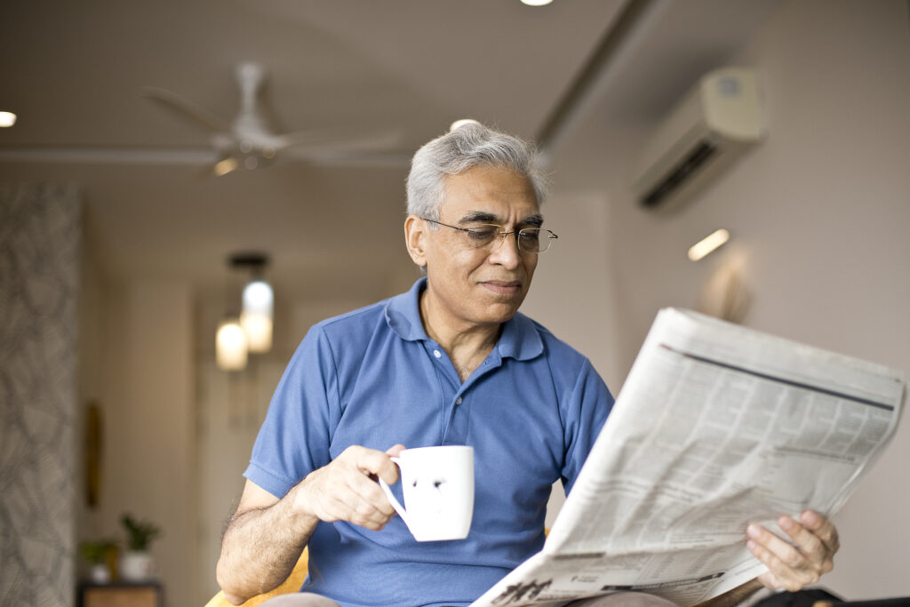 Man drinking coffee and reading newspaper