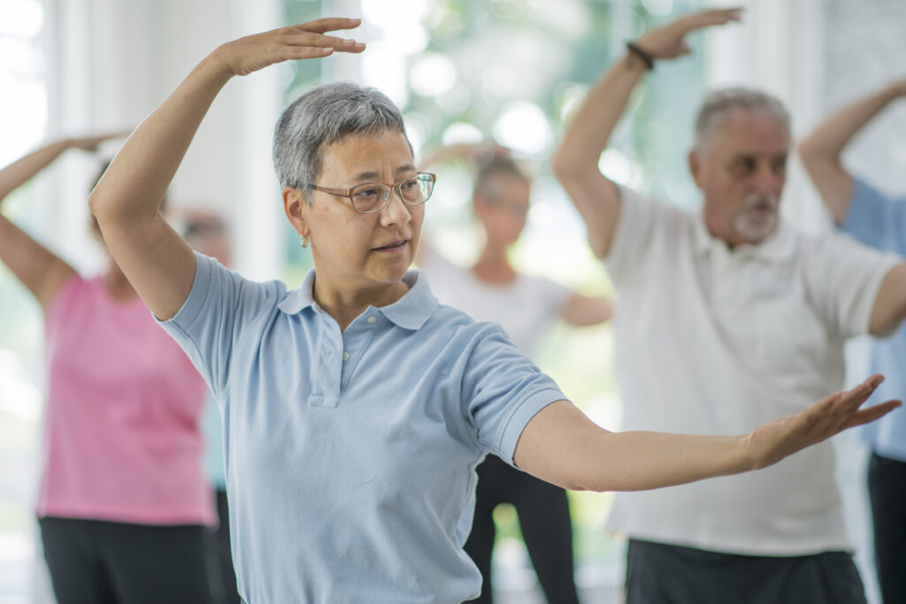 an older man does tai chi with a group