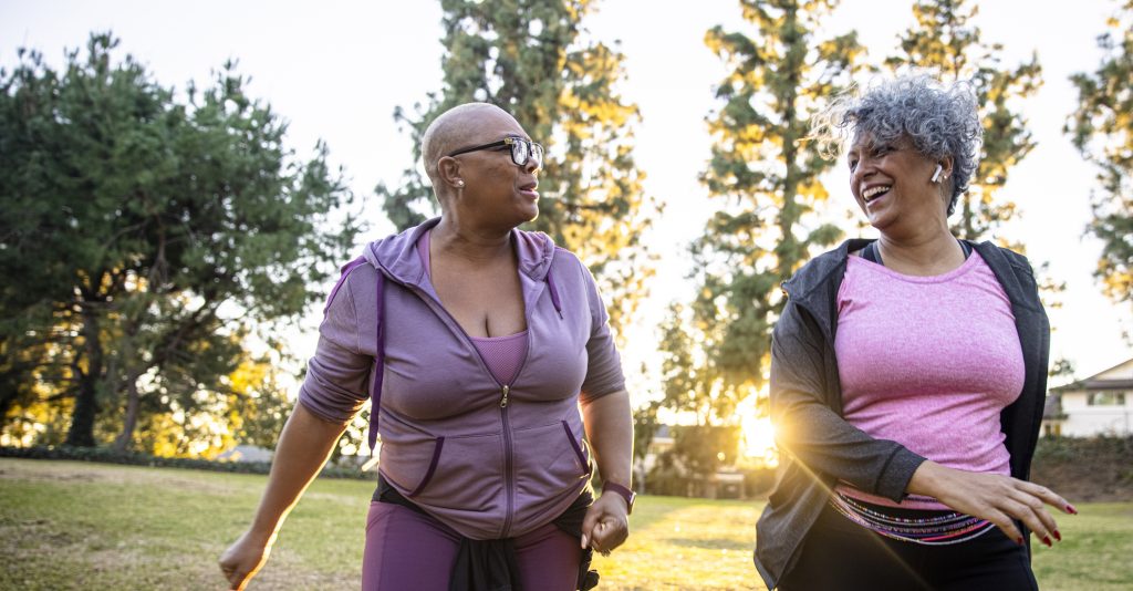 two mature women walk outdoors together