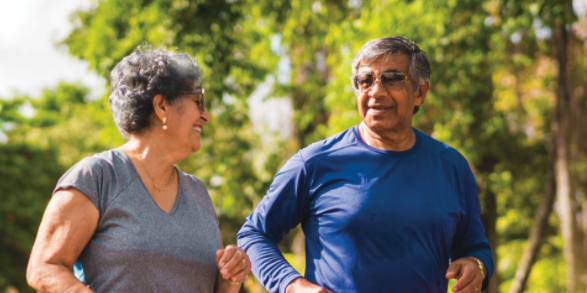 Two older adults happily walking outdoors