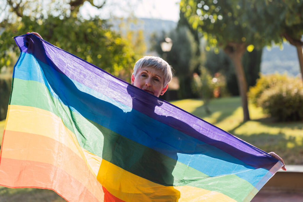 woman holds a rainbow flag