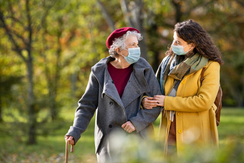 An older adult and a young person walking together
