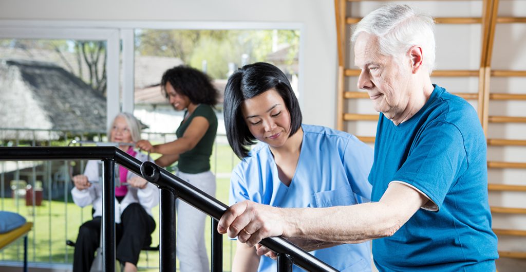 older man exercises with the help of a service provider