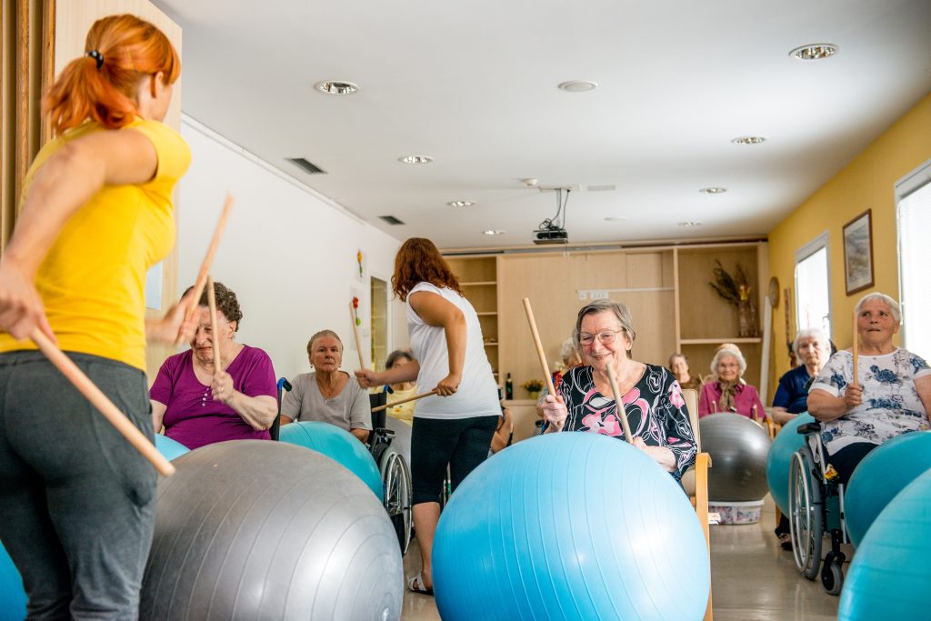 Older adults playing drums together using exercise balls